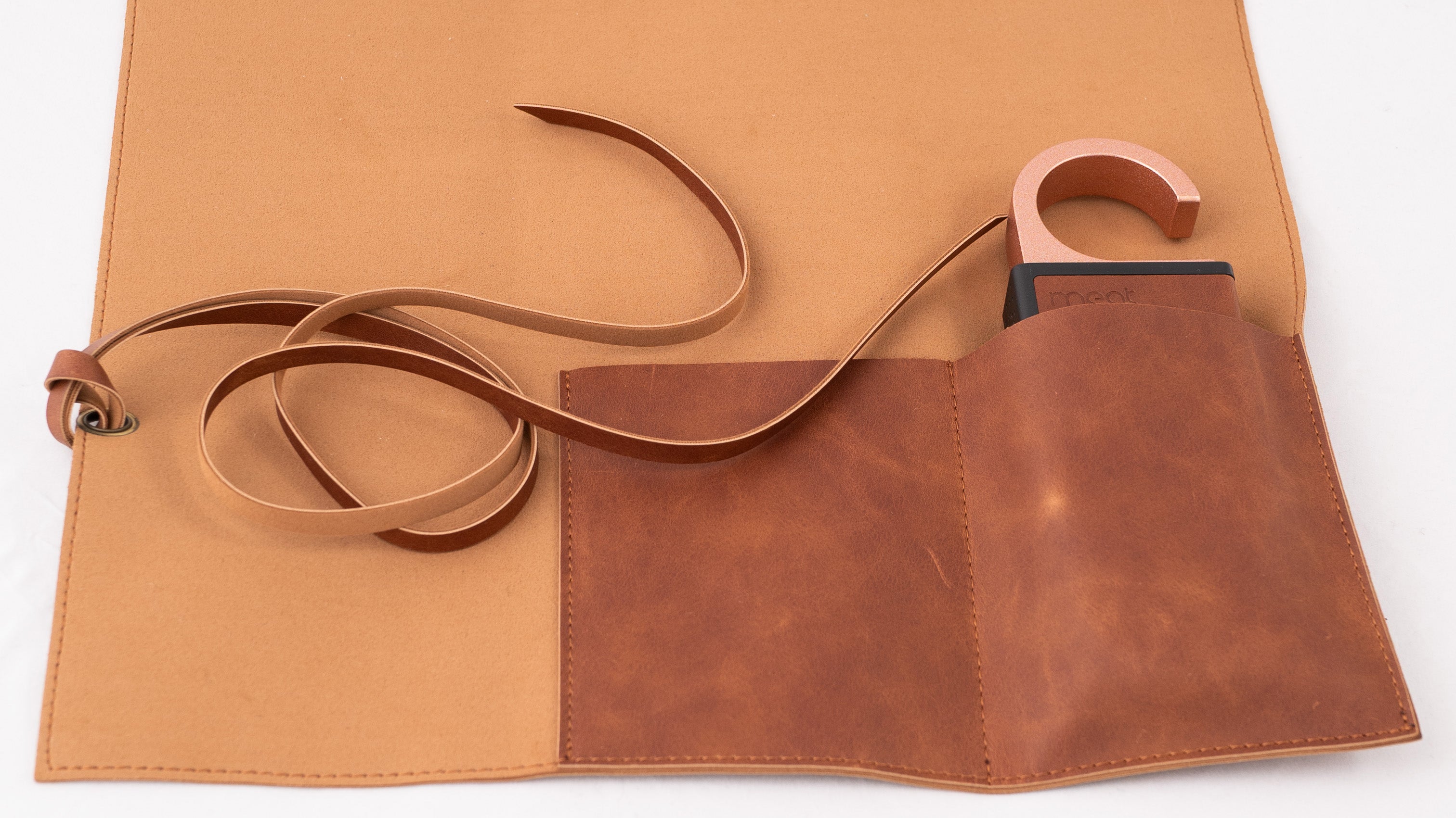 Brown tool roll with a strap on a white background
