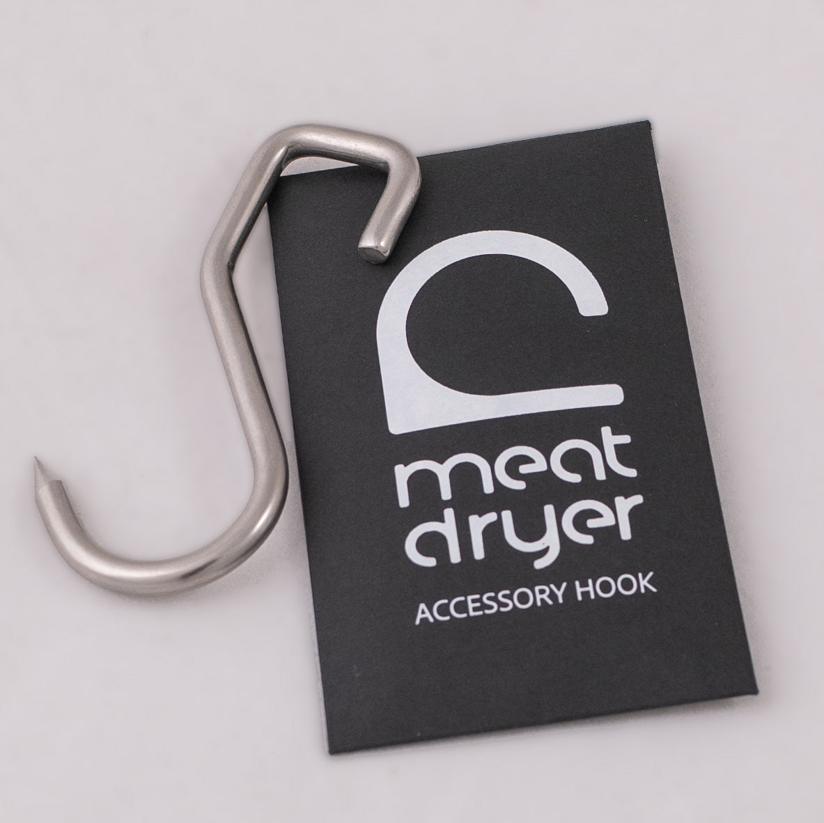 Metal meat S-hook on a black envelope with &