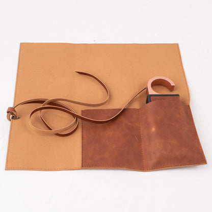 Brown tool roll with strap on a white background