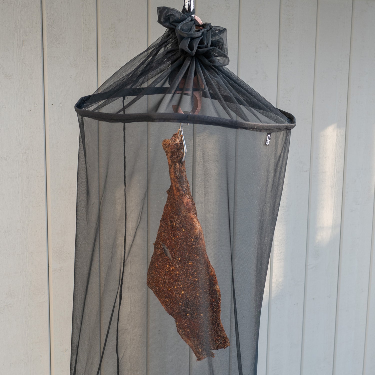 Protective net for flies and insects for meat, hanging on a meatdryer hook