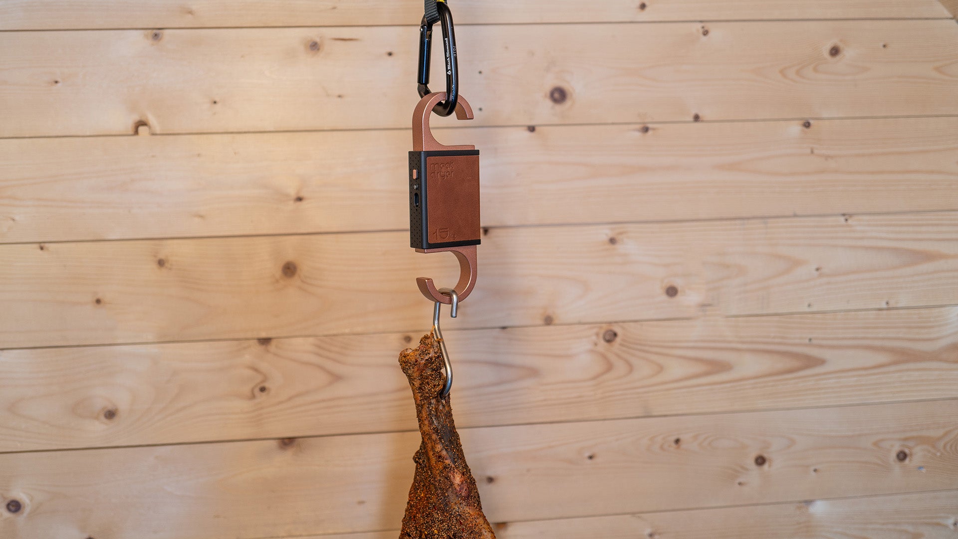 Hanging cured meat on a hook against a wooden wall